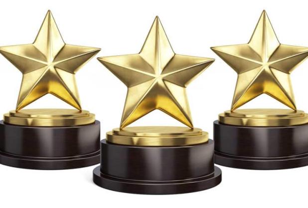 Stock image of three trophies in the shape of stars.